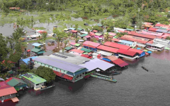 Village de commerçants inondé au Suriname en face de Maripa-Soula. Les pirogues peuvent directement accoster dans les magasins.